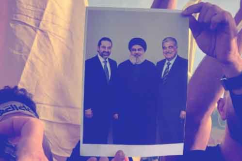 مشاركون في فعالية الروشة يرفعون صور السيد الشهيد، والرئيس الشهيد رفيق الحريري والرئيس سعد الحريري.